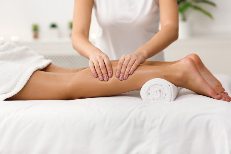 Massage,Therapist,Massaging,Woman,Calves,In,Spa,Center,,Side,View